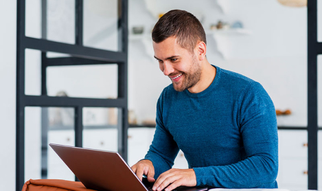 Homem sorrindo utilizando notebook na renovação do certificado digital